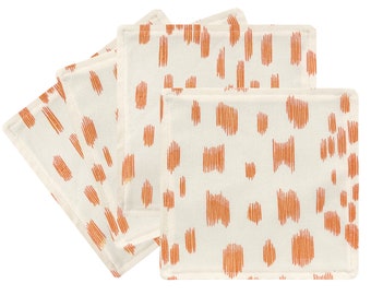 May include: Set of four off-white cotton napkins with a geometric pattern of orange lines. The napkins have a subtle texture and a slightly frayed edge.