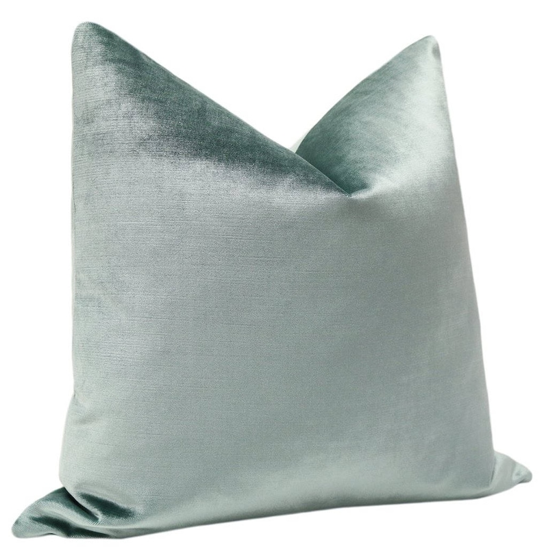 May include: A light blue velvet pillow with a smooth, silky texture. The pillow is rectangular and has a slightly pointed top.