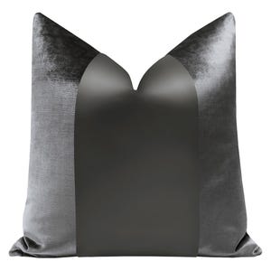 May include: A gray velvet pillow with a black satin center panel. The pillow has a simple, elegant design.