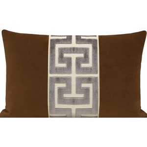 May include: A brown velvet pillow with a white and gray geometric pattern down the center.