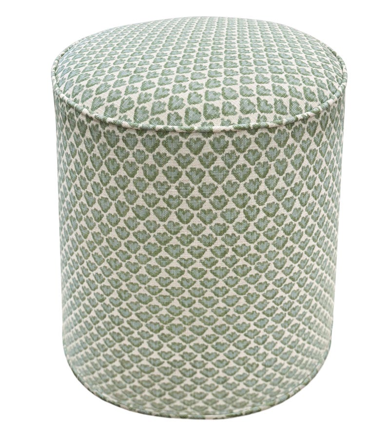 Pode incluir: Um pufe cil&iacute;ndrico com um tecido estampado. O tecido apresenta um design repetido de formas verdes em forma de folha sobre um fundo creme. O pufe tem uma parte superior e inferior arredondadas e mede aproximadamente 46 cm de di&acirc;metro e 46 cm de altura.