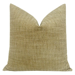 May include: A square throw pillow with a herringbone pattern in shades of beige and brown.