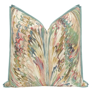 May include: Decorative throw pillow with a marbled pattern in shades of pink, green, blue, and beige. The pillow has a teal border. This accent pillow adds a touch of color and style to any living space.