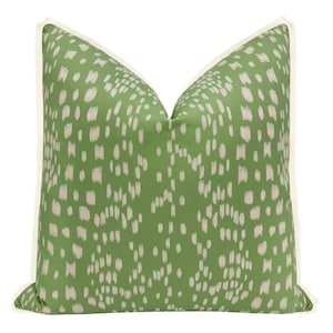 May include: Green and white patterned throw pillow with a white border. The pillow has a geometric pattern of white dots and dashes on a green background.