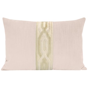 May include: A rectangular decorative pillow in a light pink hue. The pillow features a vertical band of embroidered geometric patterns in a soft, muted gold color, adding a touch of elegance to the design. The pillow is a home decor item.