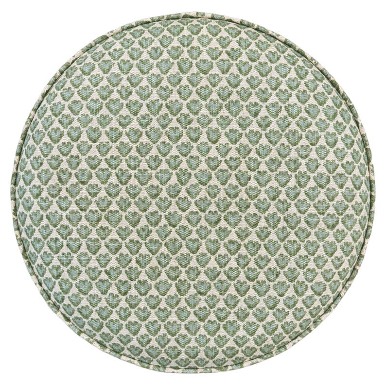 Pode incluir: Uma almofada redonda com um padr&atilde;o repetido de formas florais verdes sobre um fundo creme. A almofada tem uma borda com debrum e &eacute; projetada para uso decorativo. O design geral &eacute; um tema bot&acirc;nico cl&aacute;ssico.