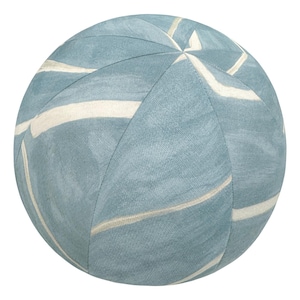 May include: A round, light blue pouf with a white, wavy pattern. The pouf is a sphere shape, with the white pattern creating a striped effect. The pouf is made of a soft, textured fabric. Home decor item.