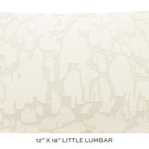 May include: A white lumbar pillow with an abstract pattern in a lighter shade of white. The pillow measures 12 inches by 18 inches and is labeled "Little Lumbar".