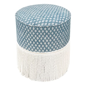 May include: A cylindrical ottoman featuring a blue fabric top and sides with a repeating white geometric pattern. The lower portion of the ottoman is adorned with a thick layer of white rope fringe that hangs down to the base of the furniture piece.