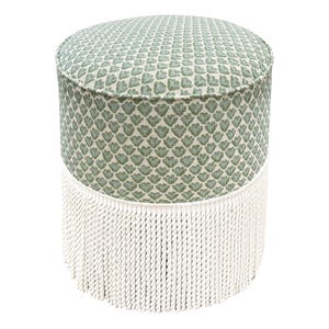 Pode incluir: Um pufe redondo com um padr&atilde;o floral verde e branco na parte superior e nas laterais. A base do pufe &eacute; adornada com uma franja branca. Uma pe&ccedil;a de mobili&aacute;rio decorativa.