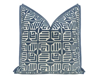 May include: A blue and white geometric patterned throw pillow with a blue border.