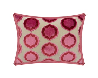 May include: Rectangular decorative pillow with a repeating floral pattern in shades of pink and red on a light beige background. The pillow has a pink border, adding a contrasting accent. This accent pillow is designed for home decor.