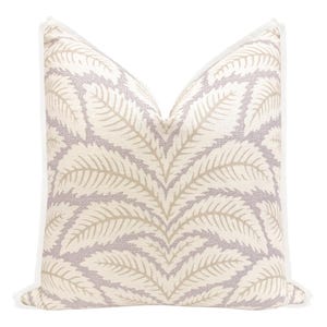 May include: A decorative throw pillow with a white background and a pattern of beige leaves on a light purple background. The pillow has a white piping around the edges.