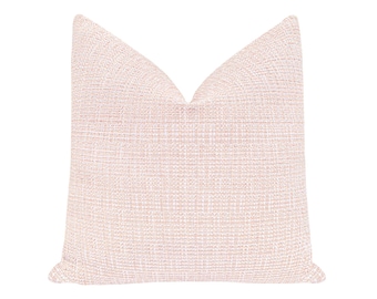 May include: A square decorative pillow with a woven texture in a light pink color. The pillow has a classic shape and is designed for home decor. The fabric appears soft and comfortable, suitable for a living room or bedroom setting.