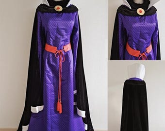 May include: A purple costume with a gold crown, black cape, and orange belt. The long dress has a high collar and a red jewel. The black cape has white trim. The costume is displayed on a mannequin.