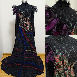 Puede incluir: Un vestido negro y morado de varias capas con un corpiño bordado con flores y una falda con volantes. El vestido tiene cuello alto y mangas largas.