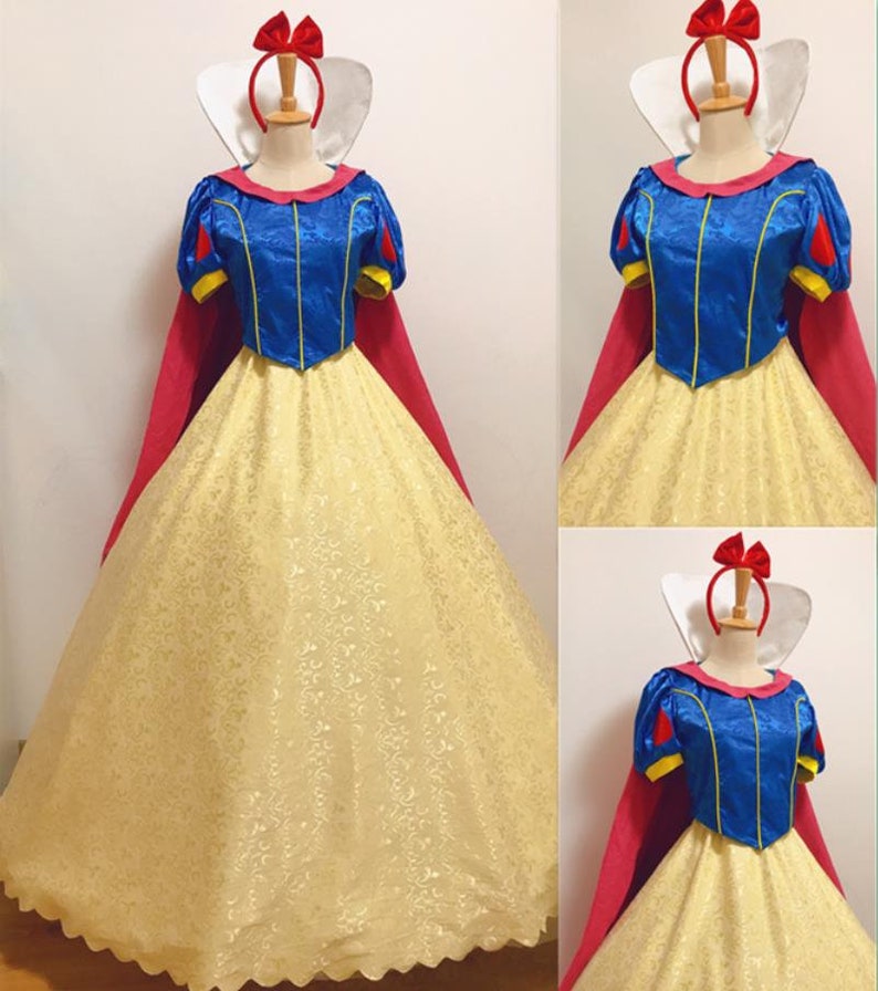 May include: A Snow White costume with a yellow and white dress, a blue bodice, a red cape, and a red headband with a bow.