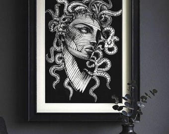 May include: Black and white framed art print featuring a detailed illustration of Medusa's face. The artwork showcases a woman's face with intricate line work and snakes for hair, set against a black background. The print is displayed in a black frame.