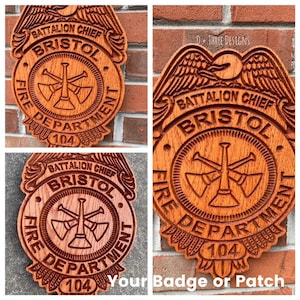 May include: A wooden plaque with a carved image of a fire department badge. The badge features a crossed set of trumpets, the words "Battalion Chief", "Bristol", "Fire Department", and the number "104".