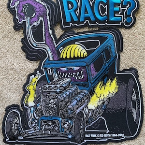 May include: An embroidered patch featuring a cartoon hot rod in blue and purple with flames, a monster driver, and the text "RACE?" and "RAT FINK © ED ROTH 1984-2012".