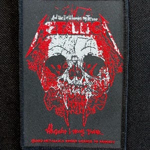 May include: Black rectangular patch featuring a red and white skull design with the band name "Metallica" and the text "And the Evil Unleashes My Throne". The patch also includes the text "Master I Never".