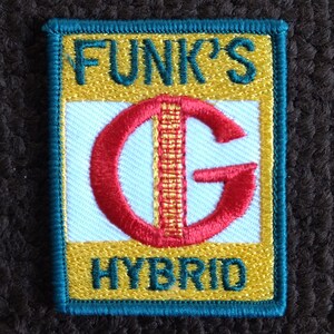 May include: An embroidered patch in teal, yellow and red with the text "Funk's G Hybrid"