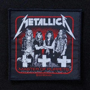 Puede incluir: Un parche cuadrado negro con la banda Metallica. El parche tiene un borde rojo con el nombre de la banda en letras blancas estilizadas. Debajo del nombre de la banda hay un gráfico de los miembros de la banda y el texto "MASTER OF PUPPETS".