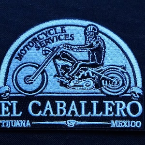 May include: Blue and white embroidered patch with a motorcycle and the text "Motorcycle Services El Caballero Tijuana Mexico".