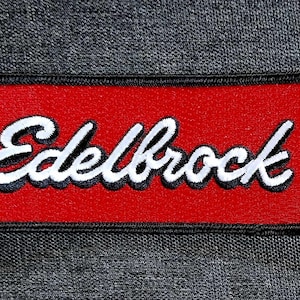 May include: Red rectangular patch with black stitching and the white text "Edelbrock" in a stylized font.