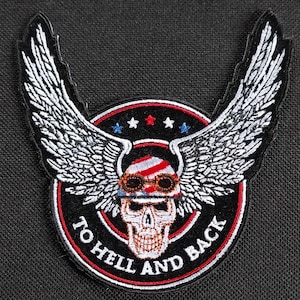 Könnte beinhalten: Ein gestickter Patch in Schwarzweiß mit einem Totenkopf, der ein rot-weiß-blaues Bandana und eine Fliegerbrille trägt. Der Totenkopf hat Flügel und der Text "To Hell And Back" ist um den Totenkopf herum geschrieben.