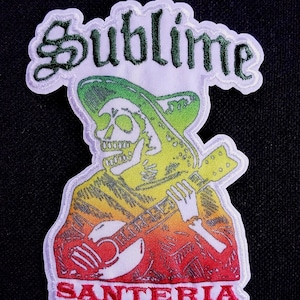 Pode incluir: Patch bordado com um esqueleto tocando guitarra, usando um chapéu. O patch tem a palavra "Sublime" em escrita verde acima do esqueleto e a palavra "Santeria" em vermelho abaixo. O design é delineado em branco.