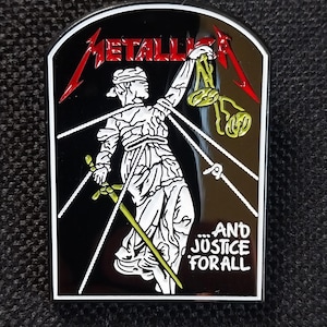 Może przedstawiać: Czarno-biała przypinka z logo Metalliki w kolorze czerwonym i przedstawieniem Lady Justice trzymającej wagę i miecz. Widoczny jest również napis "...AND JUSTICE FOR ALL".