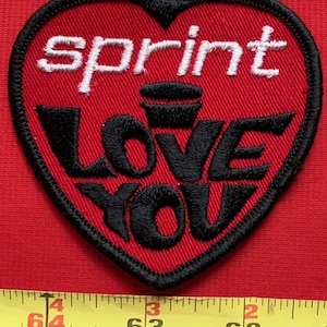 May include: Red heart-shaped patch with black embroidered text that reads "sprint love you".