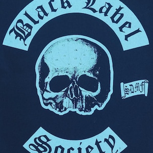 May include: A navy blue graphic with a skull illustration at the center. The words "Black Label" are arched above the skull, and "Society" is arched below. The design also includes the initials "SDMF".