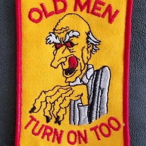 Puede incluir: Parche bordado con fondo amarillo y borde rojo. El parche presenta una imagen de dibujos animados de un anciano con ojos rojos y boca abierta. El texto "OLD MEN TURN ON TOO" está en rojo.