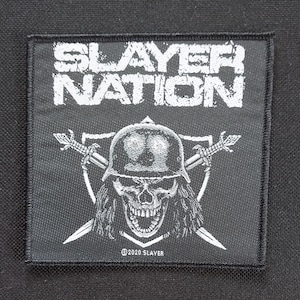 May include: Black square patch with white text "SLAYER NATION" above a skull wearing a helmet, crossed swords, and a shield. The patch has a black border and the text "©2020 SLAYER".