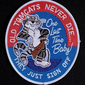 Peut inclure: Écusson brodé avec un chat de dessin animé tenant un objet marron. L'écusson a un fond bleu avec le texte "One Last Time Baby" et "They Just Sign Off". Le cercle extérieur est rouge avec le texte "Old Tomcats Never Die..."