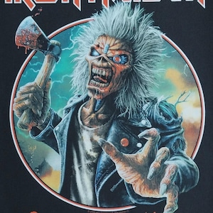 May include: Black graphic tee featuring the band Iron Maiden. The design includes the band's logo in orange, and a zombie-like figure holding a bloody axe. The text "Run For Your Lives" is printed in orange.