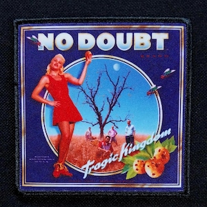 May include: Square patch featuring the words "NO DOUBT" in white block letters above an image of a woman in a red dress. The image includes a tree, people, and the words "Tragic Kingdom".