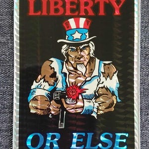 May include: A black and white sticker with a cartoon image of Uncle Sam holding a gun. The sticker says "LIBERTY OR ELSE" in red and blue letters.