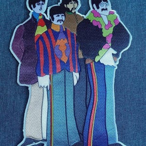 May include: Embroidered patch featuring a stylized depiction of four figures, each with distinct hairstyles and attire. The figures are dressed in colorful outfits, including striped jackets, floral accents, and tailored pants. The patch has a white border.