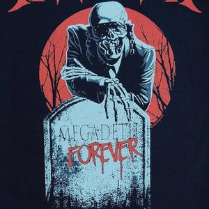 Puede incluir: Camiseta negra con el nombre de la banda "MEGADETH" en rojo, con letras estilizadas. Una figura esquelética con traje se apoya en una lápida con "MEGADETH FOREVER" en rojo. Un círculo rojo y ramas de árboles desnudas en el fondo.