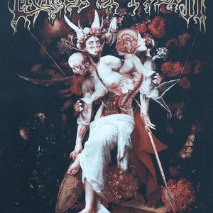 May include: Black t-shirt featuring artwork for the band Cradle of Filth. The design includes figures with exposed anatomy, floral elements, and the text "THE SCREAMING OF THE VALKYRIES". The band's logo is at the top.