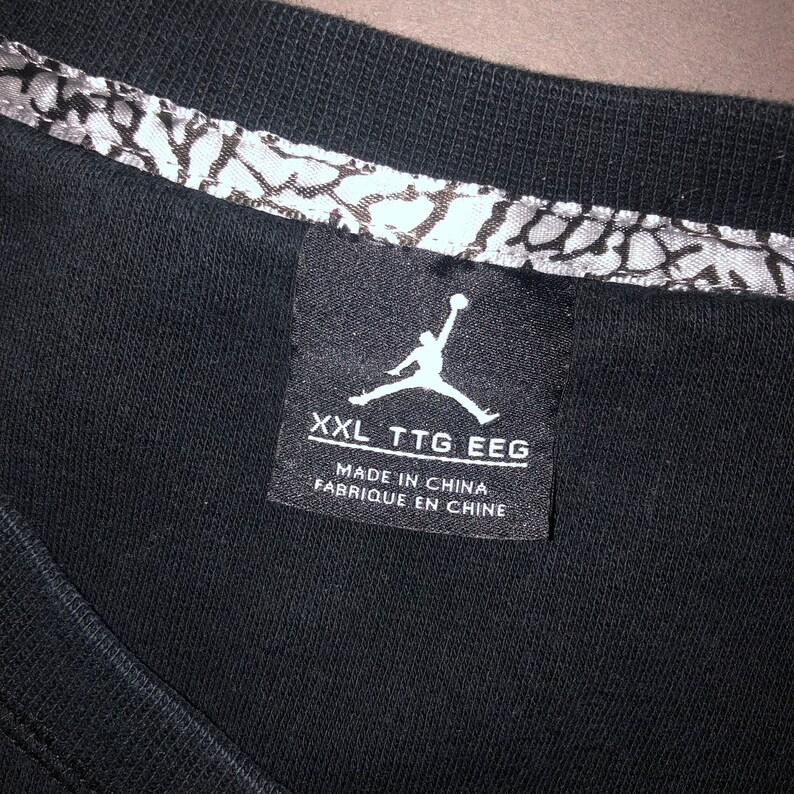 May include: Black t-shirt with a white Jordan logo and text that reads "XXL TTG EEG Made in China Fabrique en Chine".