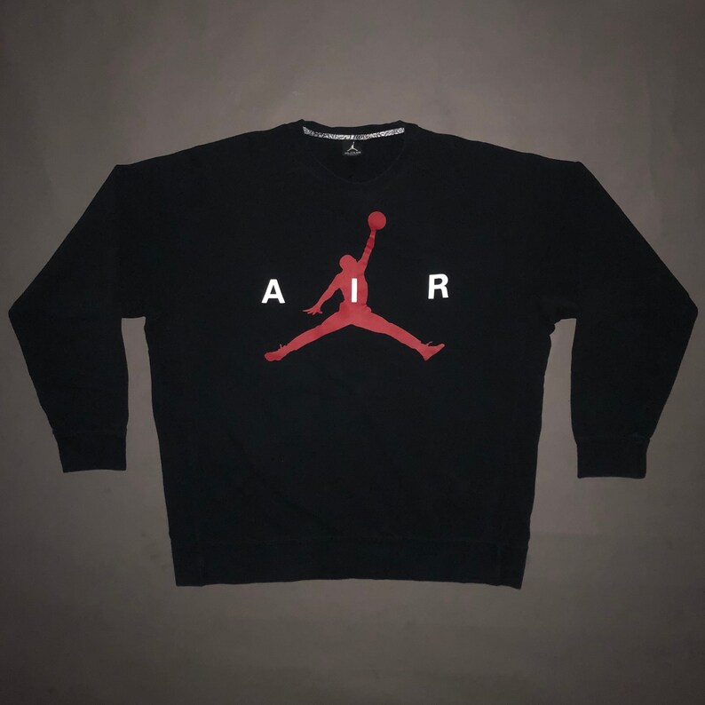 May include: Black sweatshirt with a red silhouette of a basketball player and the word "AIR" in white letters.