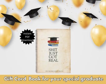 May include: A graduation gift card book with a gold and black cover. The cover features a graduation cap and the text "Shit Just Got Real".