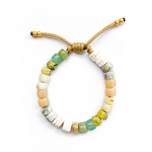 May include: A green, white, and peach beaded bracelet with a gold cord closure.