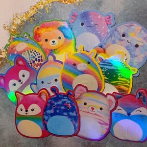 May include: A collection of colorful plush toys with various animal and creature designs. The toys are made of soft, fuzzy material and have bright, vibrant colors. Some of the toys have iridescent finishes, adding to their visual appeal.
