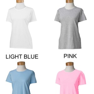 May include: Four women's t-shirts in different colors: white, heather grey, light blue, and pink. The shirts are displayed on mannequins against a white background.  WOMEN'S SHIRTS is written at the top of the image.  The colors of the shirts are labeled below each mannequin.