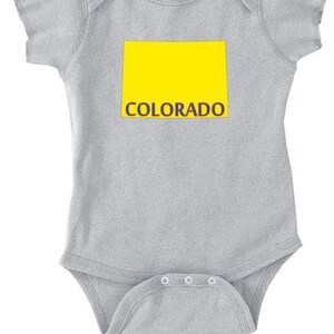 May include: A gray baby onesie with a yellow outline of the state of Colorado and the word "COLORADO" in blue lettering.